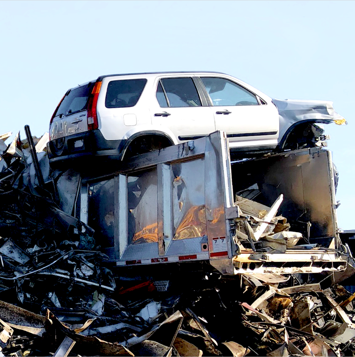 Junk car being loaded onto a pile of scrap metal at Chet's scrap yard in Springfield, MA